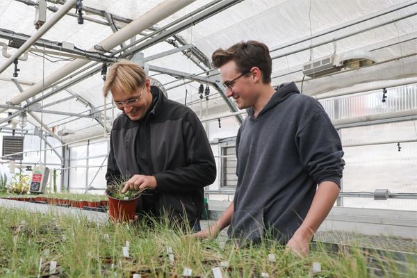 教师 member, Robert Pal, and a student looking at plant samples